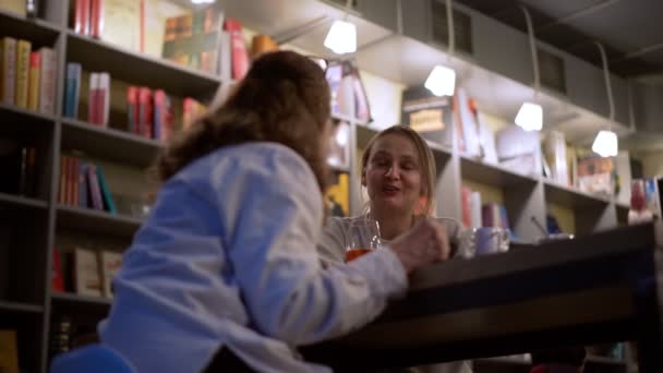 Dospělá dospělá žena sedí večer v kavárně se svou dospělou dcerou, — Stock video