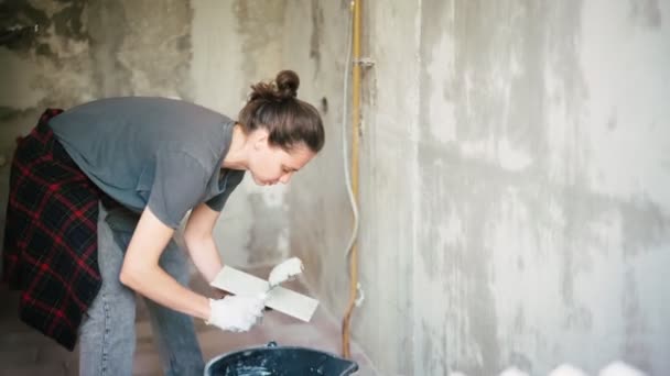 Una reparadora profesional pone un yeso en la pared con una espátula. — Vídeos de Stock