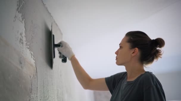 Profesyonel bir tamirci duvara spatulayla sıva yapıştırır.. — Stok video