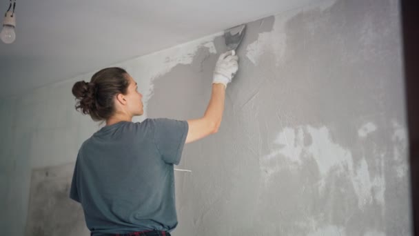 プロの修理の女性はヘラで壁に石膏を置きます. — ストック動画