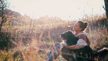 Tüylü köpeğini okşayan genç bir kadının portresi.