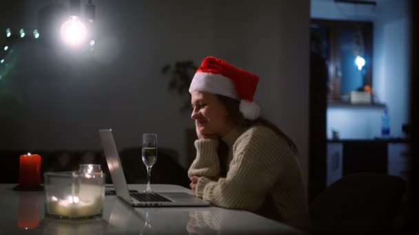 Mujer en un sombrero de Santa tomando una videollamada en un portátil con amigos — Vídeo de stock