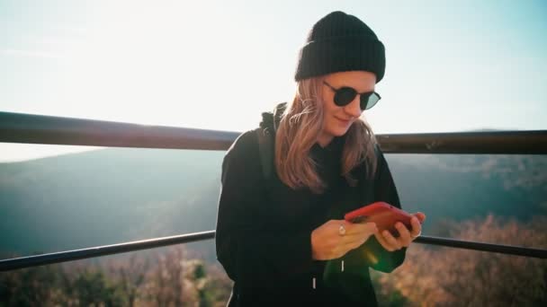Una giovane donna con gli occhiali da sole che si fa un selfie sul telefono — Video Stock