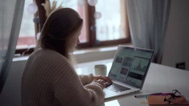 Laptop ekranına bakan genç bir kadının arka planı.