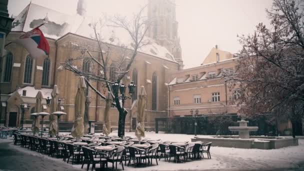 在降雪期间，一个有喷泉和封闭咖啡馆的正方形的电影拍摄 — 图库视频影像
