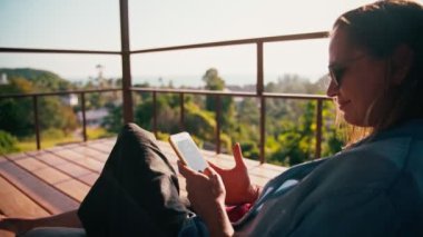 Close-up shot of a young adult cheerful woman using her smartphone