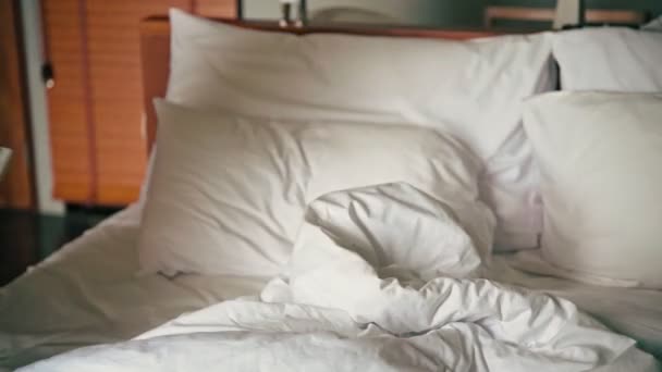 Молода жінка лежить в ліжку з телефоном в руках . — стокове відео