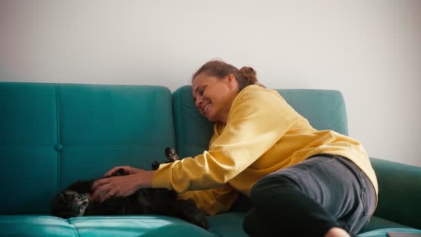 Una joven adulta alegre jugando con su lindo gato — Vídeo de stock