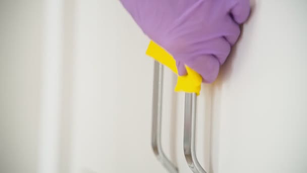 Close-up shot of a hand in a latex glove cleaning handles of the closet — Stock video