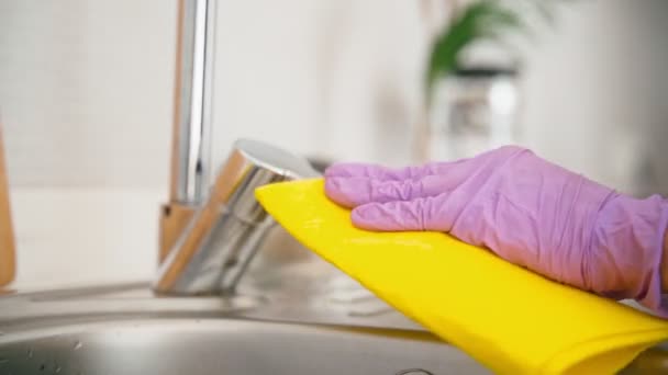Close-up shot of hands in latex gloves polishing faucet — Video