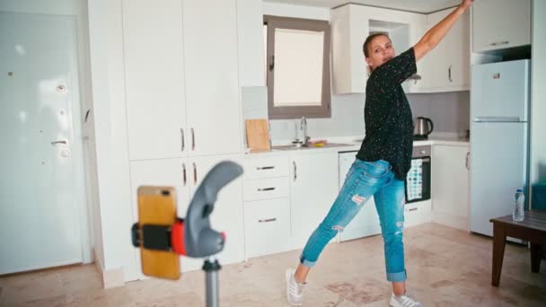 Young adult cheerful woman leads an online dance class from her apartment — Stock video