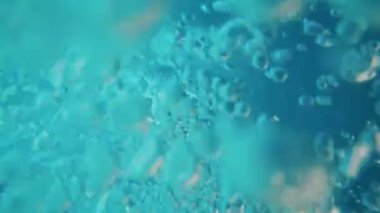 Lots of air bubbles float in the blue water of the pool.