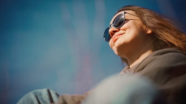 Retrato de una mujer joven adulta con gafas de sol disfrutando del aire fresco — Vídeos de Stock