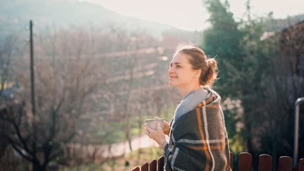 Una giovane donna che si gode il suo caffè mattutino in piedi su un balcone — Video Stock