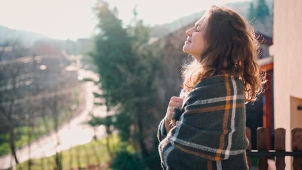 Una giovane donna attraente godendo di aria fresca mentre in piedi su un balcone — Video Stock