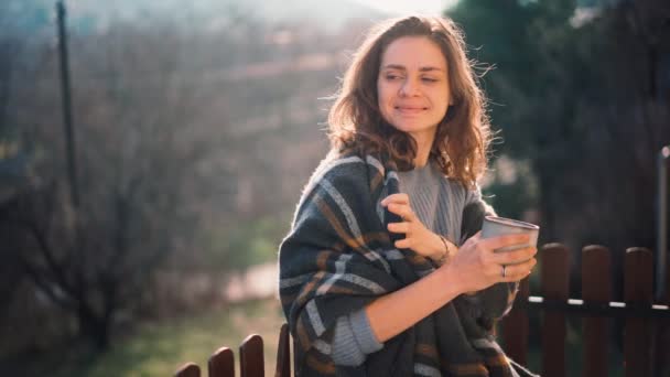 Una giovane donna che si gode il suo caffè mattutino in piedi su un balcone — Video Stock