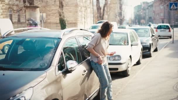 一位年轻女子打开车门，拿着钥匙，坐在司机座位上 — 图库视频影像