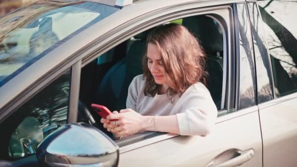 Jeune femme utilisant son smartphone assis dans la voiture. — Video