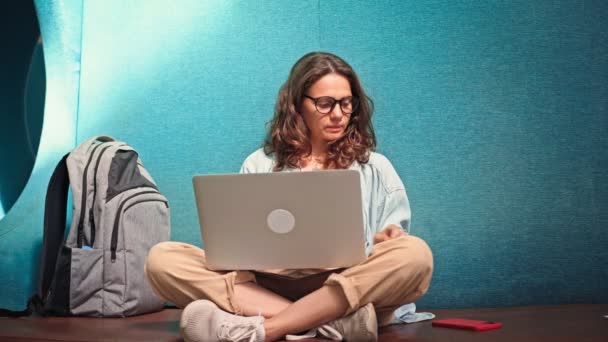 Ung Kvinna Med Glasögon Skriver Laptop Medan Hon Sitter Soffa — Stockvideo