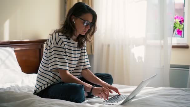 Handheld Filmowe Ujęcie Młodej Kobiety Freelancer Pracuje Laptopie Siedząc Łóżku — Wideo stockowe