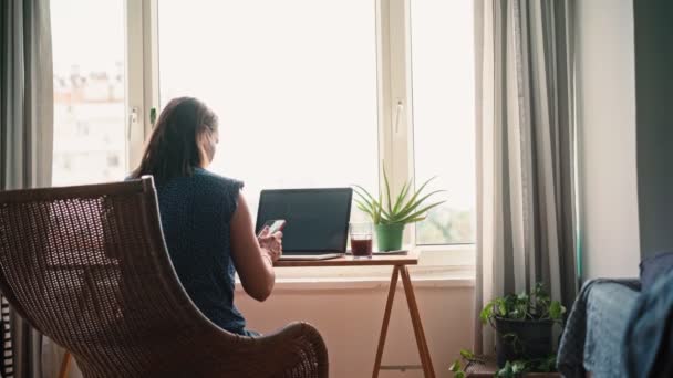 Ręczne Zdjęcie Kobiety Pracującej Laptopie Siedzącej Wiklinowym Krześle Przy Stole — Wideo stockowe