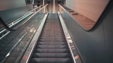 Hareket halindeki merdivenin el kamerasıyla çekilmiş yakın çekim görüntüleri. Modern yürüyen merdiven..