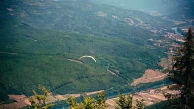 Tepenin tepesinden uçan paraglider. Aktif yaşam tarzı ve ekstrem spor macera konsepti.
