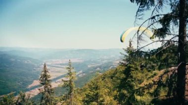 Tepenin tepesinden uçan paraglider. Aktif yaşam tarzı ve ekstrem spor macera konsepti.