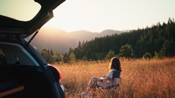 Кінематографічний Знімок Молодої Жінки Сидить Розкладному Кріслі Насолоджується Заходом Сонця — стокове відео