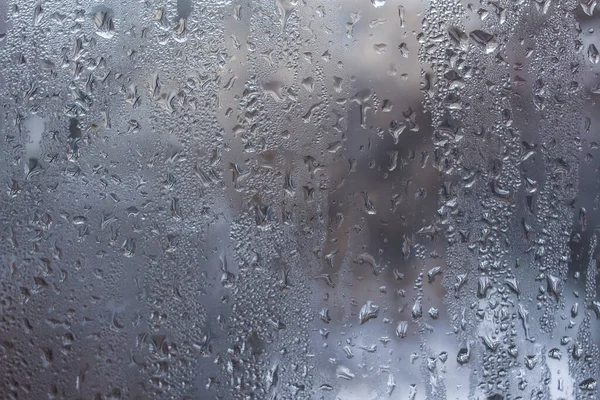 Misted glass. Rain outside the window. Water paths. For the background.