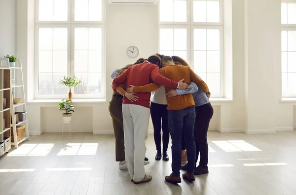 Grupp bestående av olika vänner eller kollegor som står tillsammans i ett modernt ljuskontor — Stockfoto