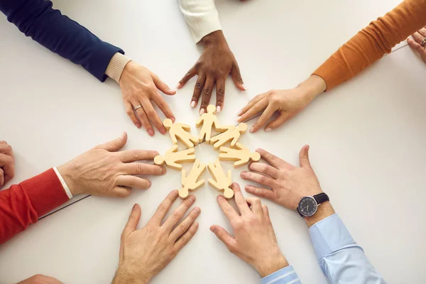 Equipo de empresarios se unen a pequeñas figuras humanas como símbolo de trabajo en equipo y cooperación — Foto de Stock