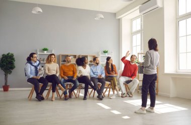 Kadın koç, şirket personeli için iş eğitimi sunuyor.