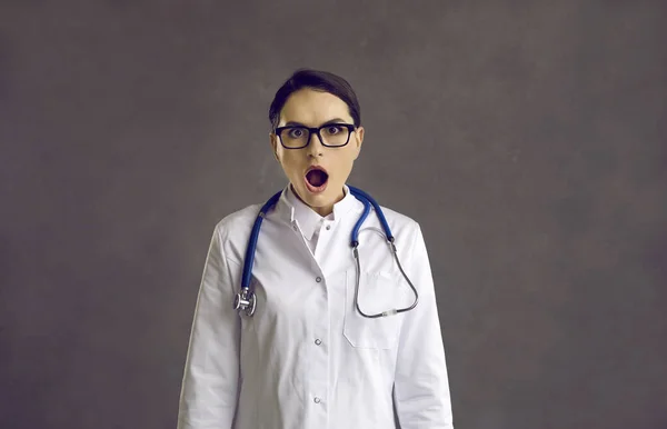 Студийный портрет шокированной медсестры или доктора с открытым ртом, смотрящего в камеру — стоковое фото