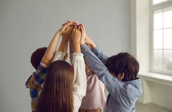 Team van kleine kinderen die dicht in de buurt staan en hun handen bij elkaar steken — Stockfoto