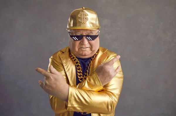 Studio portrait of cool senior man in thug life sunglasses and golden party outfit — Stock Photo, Image
