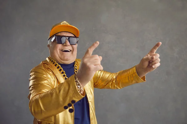 Divertente uomo anziano in giacca dorata, berretto da baseball e catena collana di ballo e divertirsi — Foto Stock