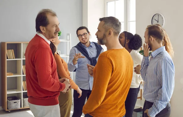 Groups of different people standing randomly and talking on business meeting