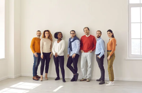 Grupp av olika personer i casual wear står tillsammans i tomt kontor eller studio — Stockfoto