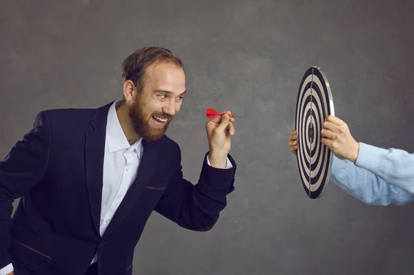 Empresario apuntando dardo en tablero de dardos como metáfora para establecer metas y objetivos — Foto de Stock