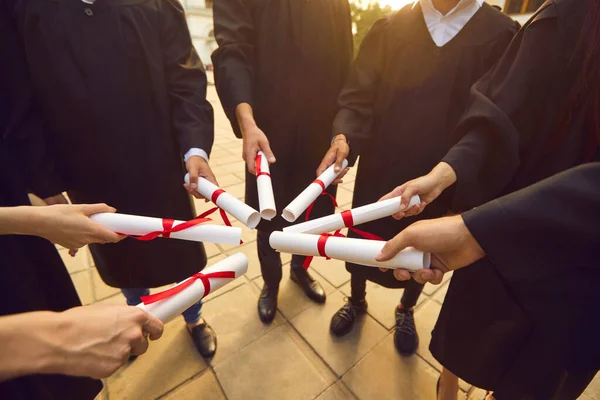 Hand of college graduates holding diploma degree certificate joining together. Graduate. — Stock Photo, Image