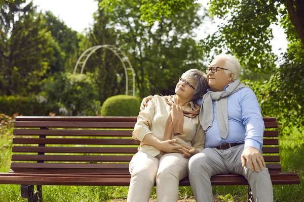 Romantisch liefdevolle oudere paar zitten op bank en knuffelen in het park — Stockfoto