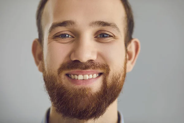 Közelkép stúdió portré egy boldog barátságos szakállas fiatalember mosolyog a kamerába — Stock Fotó