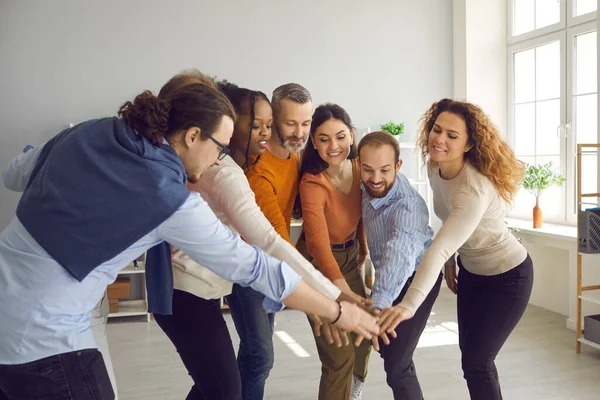 Grupo de felizes motivados diversos empresários juntando as mãos em reunião de escritório — Fotografia de Stock