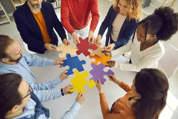 Équipe d'affaires joignant des pièces de puzzle comme métaphore pour le travail d'équipe et trouver la solution au problème — Photo