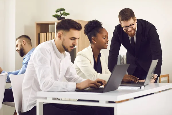 Diversos empresarios que utilizan ordenadores portátiles y trabajan juntos en proyectos digitales —  Fotos de Stock