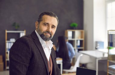 Yakışıklı bir üst düzey yöneticinin portresi bulanık bir ofis geçmişine karşı.