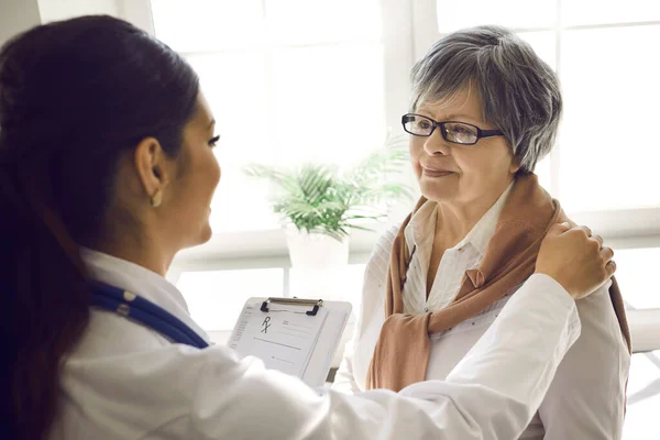 Souriant soignant jeune infirmière médecin soutien femme âgée patient gros plan — Photo