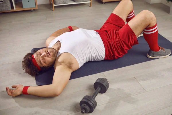 Hombre cansado perezoso con sobrepeso durmiendo acostado en la esterilla después de entrenar con pesas — Foto de Stock