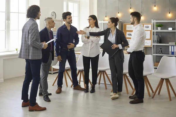 Leader and business team members talking standing in semicircle in office — Foto Stock